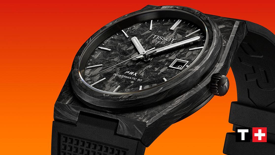 Eine Tissot-Uhr aus schwarzem Carbon vor orangefarbenem Hintergrund.