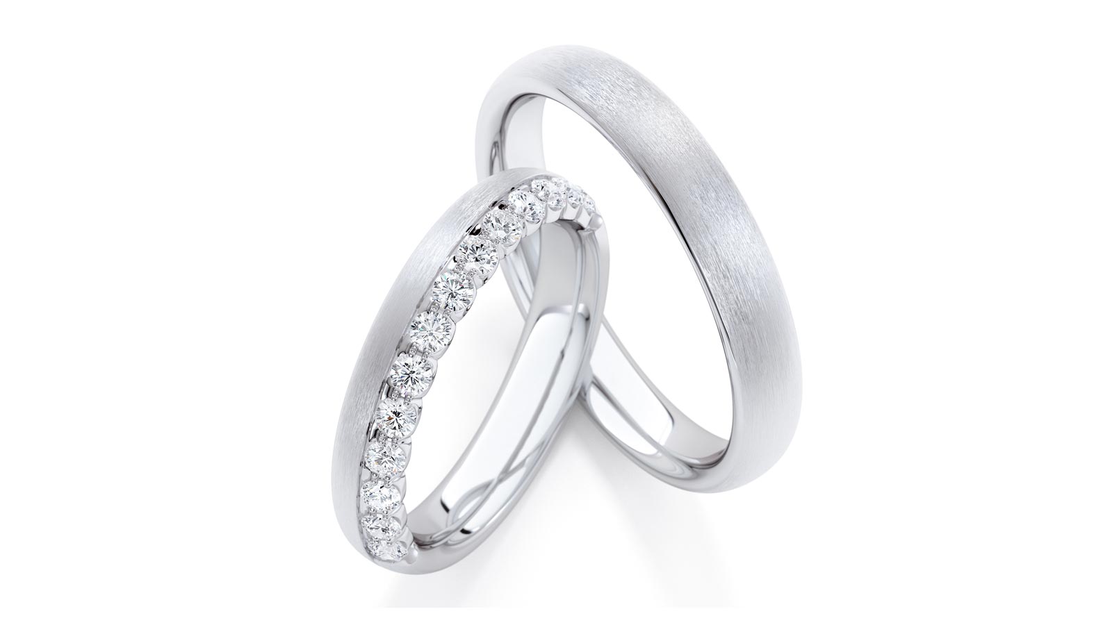 Trauringe aus Platin, einer mit Diamanten besetzt, glänzender und matter Schimmer.