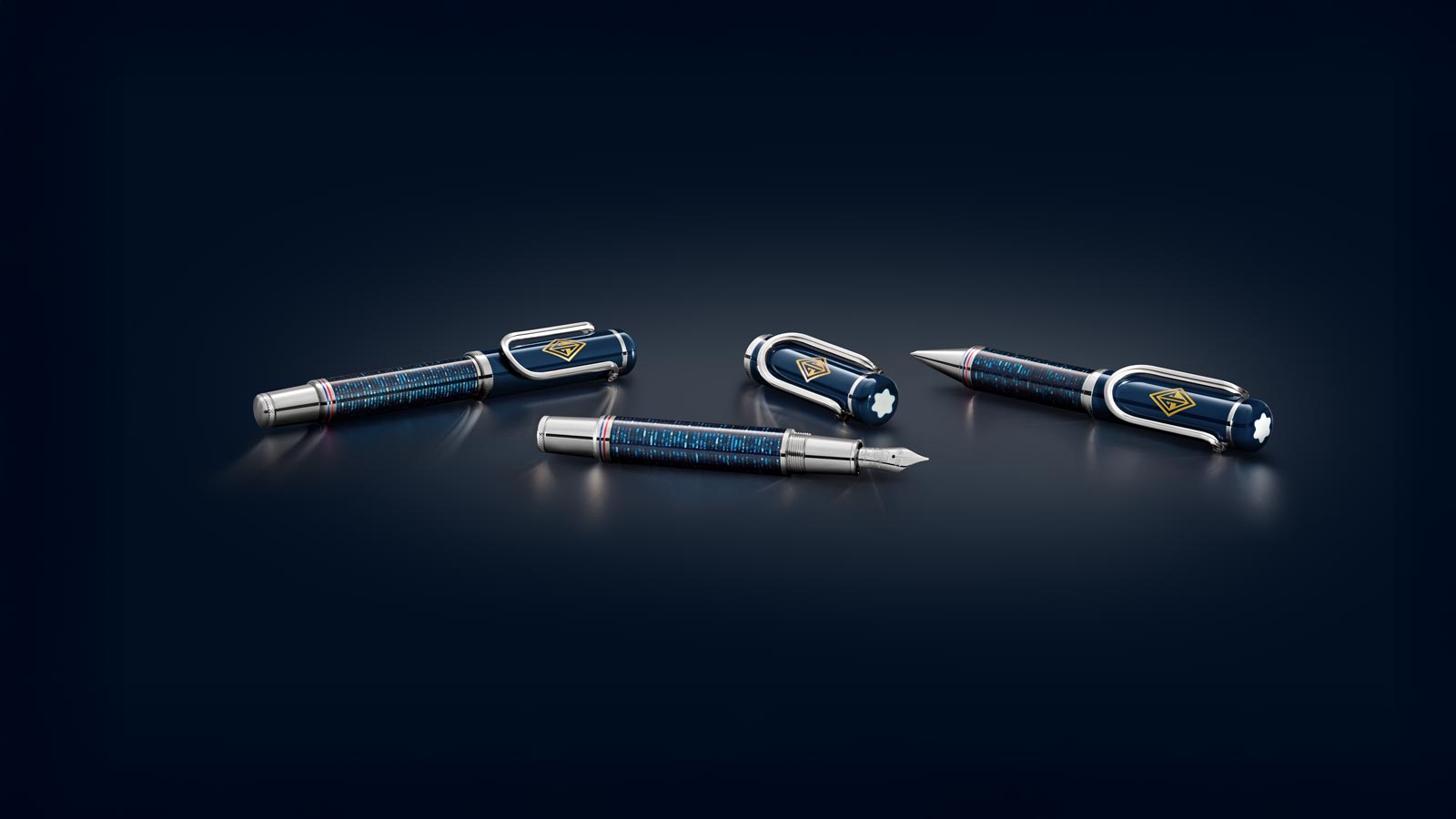 Drei elegante Füllfederhalter und ein Kugelschreiber in Blau und Silber auf einer dunklen Oberfläche.