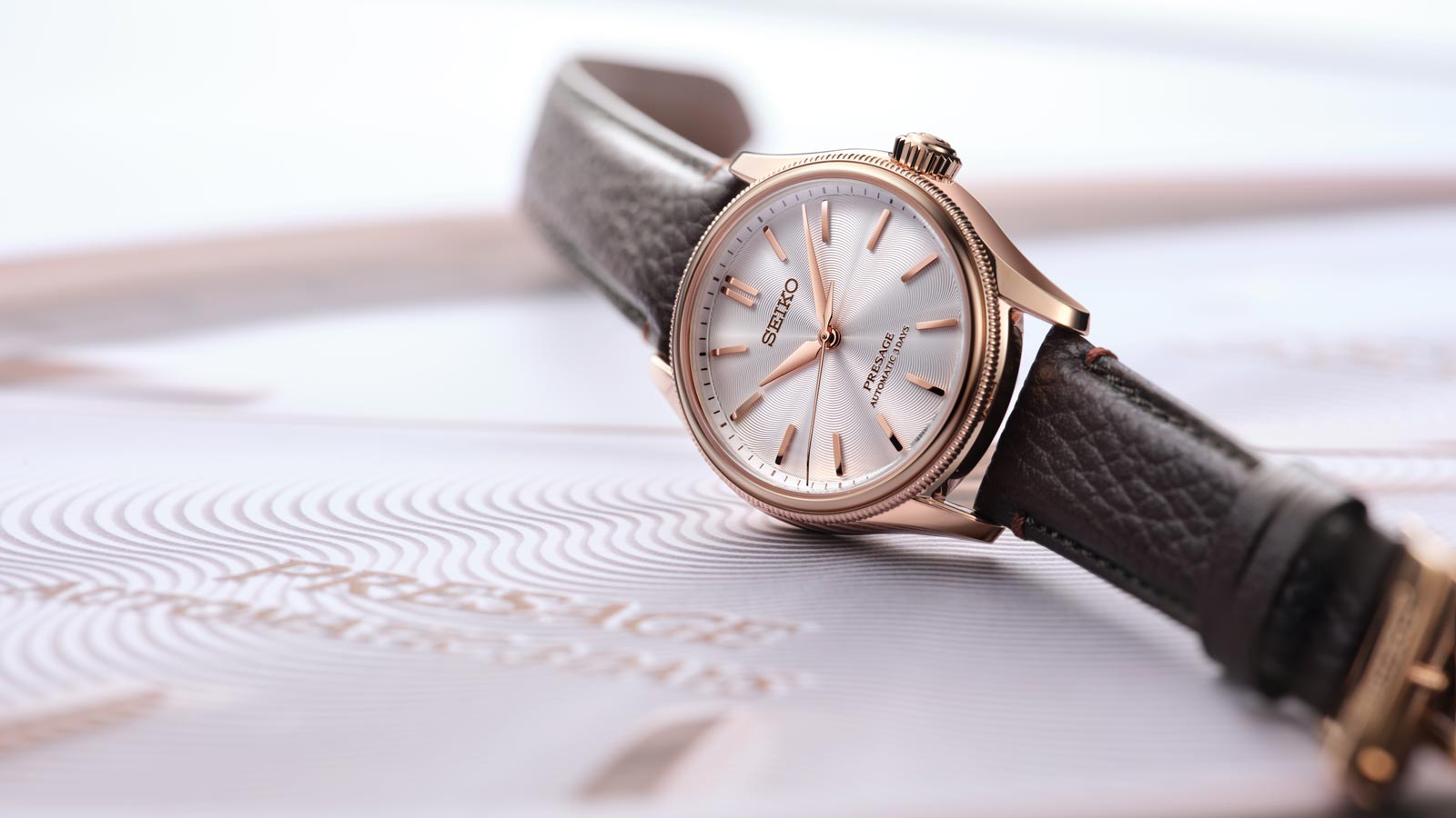 Elegante Seiko Presage Armbanduhr mit rosegoldenem Gehaeuse und braunem Lederarmband